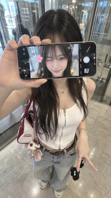 A phone held across the face, showing the face behind it